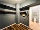 Walk-in closet with dark walls, wooden floorboards, metal bars, and a small view of the bathroom at 3412 Catherine Mermet Ave, North Las Vegas, NV 89081