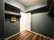 Walk-in closet with dark walls, wooden floorboards, metal bars, and a doorway leading to another room at 3412 Catherine Mermet Ave, North Las Vegas, NV 89081