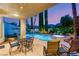 Outdoor patio with a pool, spa, shade, and landscaping at dusk at 3535 Coventry Gardens Dr, Las Vegas, NV 89135