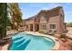 Landscaped backyard with a large pool, spa, outdoor seating, and house view at 3535 Coventry Gardens Dr, Las Vegas, NV 89135