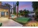 Backyard at twilight features a pool, patio, landscaping, and putting green for relaxation and recreation at 3535 Coventry Gardens Dr, Las Vegas, NV 89135