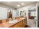 Bathroom features a dual sink vanity with a large mirror and wood cabinets at 3535 Coventry Gardens Dr, Las Vegas, NV 89135