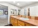 Bright bathroom featuring double sinks, tiled countertops, and a view of the doorway at 3535 Coventry Gardens Dr, Las Vegas, NV 89135