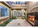 Elegant courtyard featuring an outdoor fireplace, tiled patio, and lush landscaping at 3535 Coventry Gardens Dr, Las Vegas, NV 89135