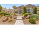 Well-maintained front yard with decorative rock landscaping, walkway, and lush greenery at 3535 Coventry Gardens Dr, Las Vegas, NV 89135