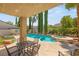 Beautiful backyard pool and spa with mature landscaping, outdoor seating, and a covered patio area at 3535 Coventry Gardens Dr, Las Vegas, NV 89135