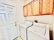 Laundry room with wood cabinets above a newer washer and dryer at 3542 Harbor Tides St, Las Vegas, NV 89147