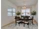 An elegant dining room features a modern chandelier, large windows, and a neutral color palette at 365 Malpaso St, Las Vegas, NV 89138