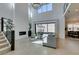 Elegant living room featuring high ceilings, stairs with glass, ample natural light, and a cozy fireplace at 365 Malpaso St, Las Vegas, NV 89138