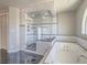 Luxurious bathroom featuring a glass shower and soaking tub with marble tile surround at 420 Dakar St, Henderson, NV 89015