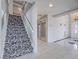 Foyer featuring tile floors, a carpeted staircase with a decorative pattern, and a chandelier above the entryway at 420 Dakar St, Henderson, NV 89015