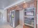 Kitchen featuring a built-in oven, microwave, stainless steel refrigerator, and custom cabinets at 420 Dakar St, Henderson, NV 89015