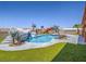 Resort-style pool featuring a rock waterfall, faux palms, lush greenery, and playful dinosaur statues creating a unique outdoor oasis at 420 Dakar St, Henderson, NV 89015