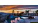 Backyard pool at sunset featuring waterfall, palms, decking, dinosaur features and lounge seating at 420 Dakar St, Henderson, NV 89015