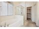 Bright bathroom showcasing a bathtub with shower, glass door, and separate closet at 4323 Village Spring St, Las Vegas, NV 89147