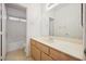 Bright bathroom has a wooden vanity with a large mirror and tiled floors at 4323 Village Spring St, Las Vegas, NV 89147