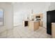Open kitchen boasts an island, tile flooring, bright cabinets, and modern appliances at 4323 Village Spring St, Las Vegas, NV 89147