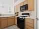 Bright kitchen features wood cabinets, black appliances and light countertops at 4323 Village Spring St, Las Vegas, NV 89147