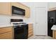 Kitchen with wood cabinets, black appliances and white countertops at 4323 Village Spring St, Las Vegas, NV 89147