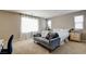 Bright bedroom with a comfortable couch, decorative pillows, natural light from large windows and bedside tables at 462 Fortissimo St, Henderson, NV 89011
