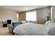 Bright bedroom featuring a comfortable bed, work space, and natural light streaming through the sheer curtains at 462 Fortissimo St, Henderson, NV 89011