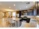 Well-lit kitchen boasts granite countertops, a functional kitchen island with seating and black cabinets with stainless appliances at 462 Fortissimo St, Henderson, NV 89011