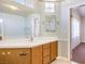 Bright bathroom features a sink with white countertop and wood cabinets beneath a large mirror at 504 Arthur Ave, Henderson, NV 89015