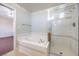 Bathroom featuring a soaking tub with tile surround and a glass-enclosed shower at 504 Arthur Ave, Henderson, NV 89015