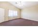Bright bedroom with neutral walls, high ceiling, ceiling fan, and carpet flooring at 504 Arthur Ave, Henderson, NV 89015