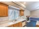 Close-up of kitchen with oak cabinets, white appliances, sink, and window at 504 Arthur Ave, Henderson, NV 89015