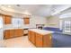 Bright kitchen with oak cabinets, a tile island, and views into a living area at 504 Arthur Ave, Henderson, NV 89015