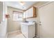 Laundry room with modern washer and dryer, cabinets, and a window at 504 Arthur Ave, Henderson, NV 89015