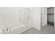 Clean, bright bathroom featuring a tub, glass shower, and sleek tile flooring at 767 Tallgrass St, Las Vegas, NV 89138