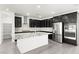 Modern kitchen with stainless steel appliances, stylish dark cabinets, granite countertops, and a center island at 767 Tallgrass St, Las Vegas, NV 89138