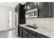 Modern kitchen with stainless steel appliances, granite countertops, and dark cabinets at 767 Tallgrass St, Las Vegas, NV 89138