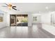 Open-concept living room with gray tile flooring, ceiling fan, and sliding glass doors to the backyard at 767 Tallgrass St, Las Vegas, NV 89138
