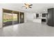 Spacious living room with gray tile flooring and a sliding glass door that opens to a patio and a kitchen at 767 Tallgrass St, Las Vegas, NV 89138