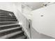 Bright staircase with carpeted steps, white banisters, and modern light fixture at 767 Tallgrass St, Las Vegas, NV 89138