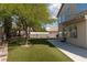 Backyard featuring artificial turf, mature trees, and patio area with ample space at 7837 Fort Ruby Pl, Las Vegas, NV 89128