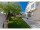 Backyard featuring artificial grass, mature trees, desert landscaping, and a concrete patio with a block fence at 7837 Fort Ruby Pl, Las Vegas, NV 89128