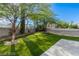 Backyard featuring artificial grass, mature trees, desert landscaping, and a concrete patio with a block fence at 7837 Fort Ruby Pl, Las Vegas, NV 89128