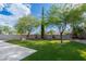 Backyard featuring artificial grass, mature trees, desert landscaping, and a concrete patio with a block fence at 7837 Fort Ruby Pl, Las Vegas, NV 89128