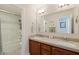 Updated bathroom featuring double sinks, a large mirror, and a glass-enclosed shower at 7837 Fort Ruby Pl, Las Vegas, NV 89128