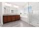 A bathroom featuring double sinks, a soaking tub, and a glass enclosed shower at 7837 Fort Ruby Pl, Las Vegas, NV 89128
