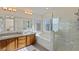Bright bathroom showcases a double sink vanity, soaking tub, and glass shower, all bathed in natural light at 7837 Fort Ruby Pl, Las Vegas, NV 89128