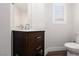 Stylish powder room with a wood vanity, neutral paint, modern fixtures, and natural light at 7837 Fort Ruby Pl, Las Vegas, NV 89128