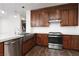 Modern kitchen boasts stainless steel appliances, dark wood cabinetry, and marble countertops at 7837 Fort Ruby Pl, Las Vegas, NV 89128