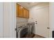 Efficient laundry room featuring a side-by-side washer and dryer and storage cabinets for convenience at 7837 Fort Ruby Pl, Las Vegas, NV 89128