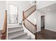Elegant staircase with wood railing, carpeted steps, and a large mirror, enhancing the entryway at 7837 Fort Ruby Pl, Las Vegas, NV 89128