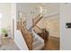 Stairway with wood railings leading to an open foyer featuring a chandelier and hardwood flooring at 7837 Fort Ruby Pl, Las Vegas, NV 89128